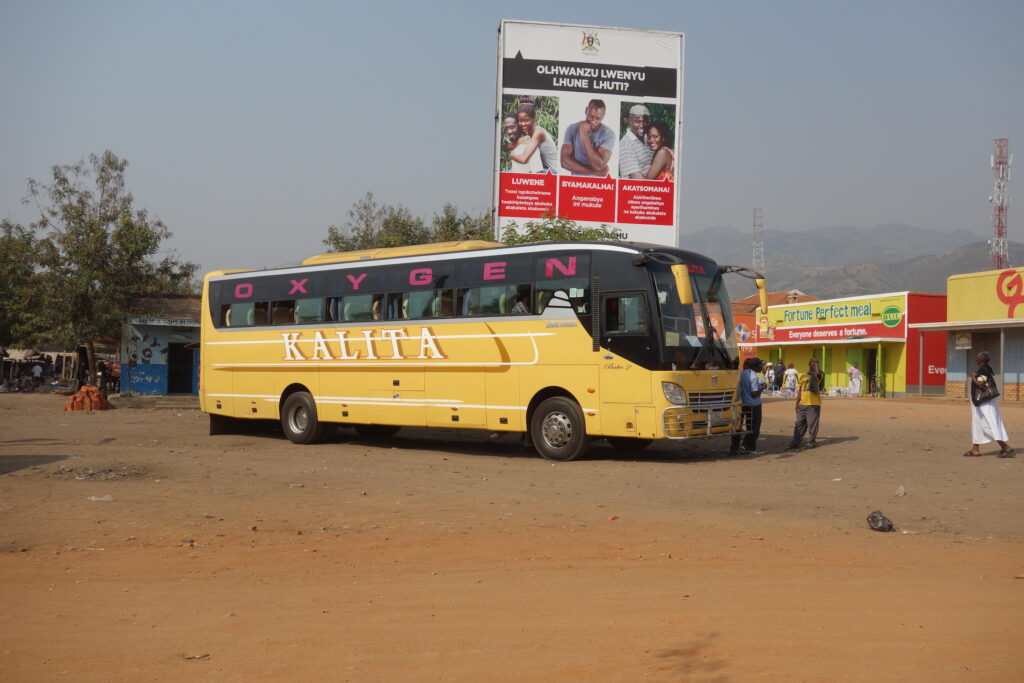 Un bus. En arrière plan, une campagne de prévention contre le virus du Sida, malheureusement très répandu en Ouganda.  
